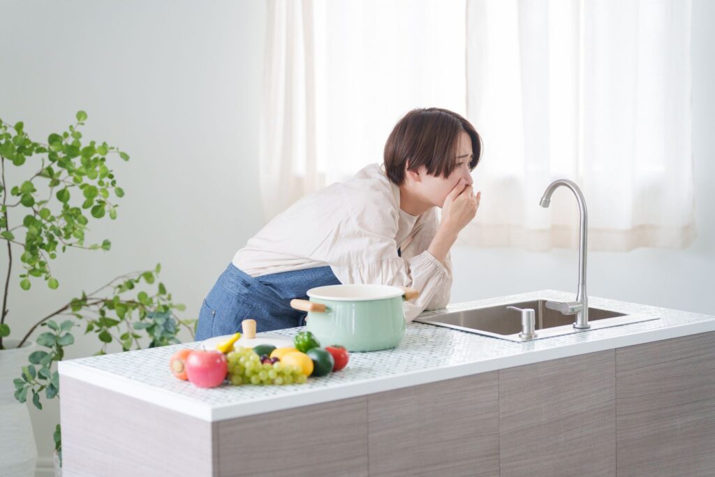 つわりで口元を押さえる女性