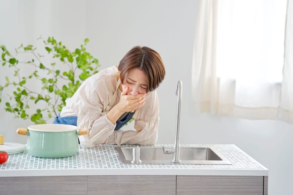 つわりで口元を押さえている妊婦