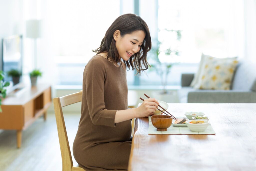 笑顔で食事を食べている妊婦