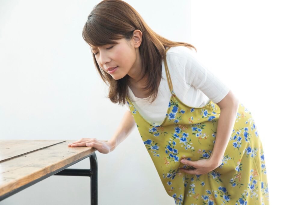 陣痛が来てお腹を押さえている妊婦