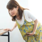 陣痛が来てお腹を押さえている妊婦