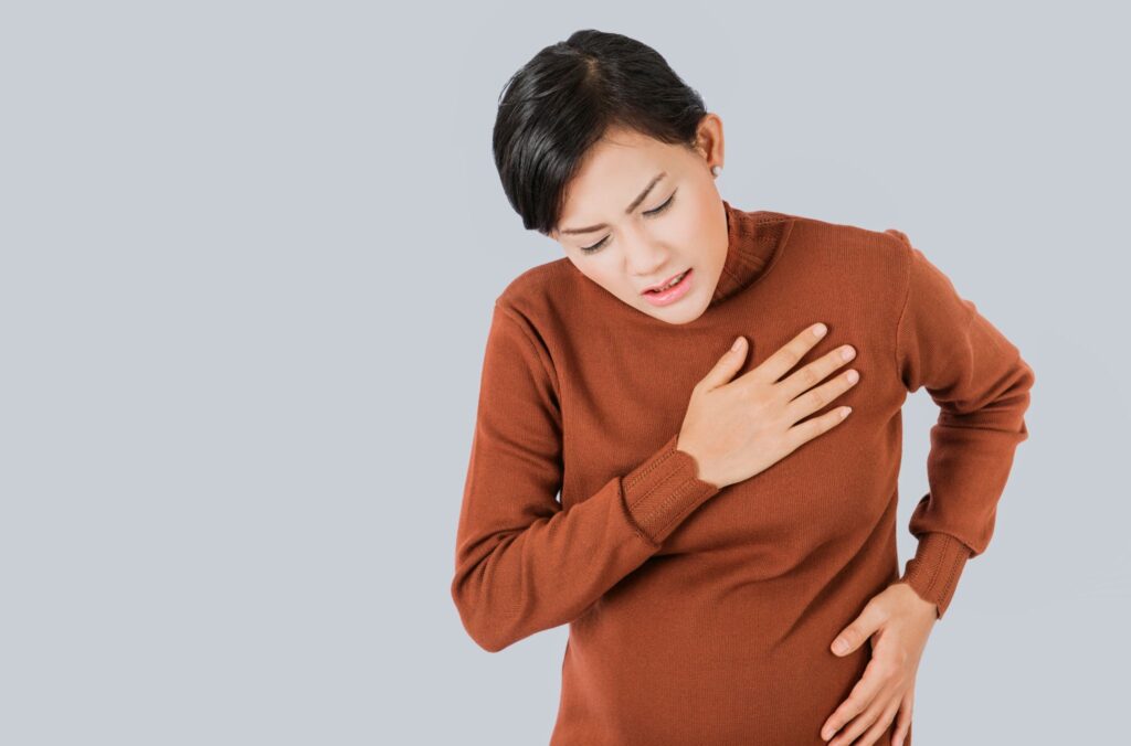 動悸を感じて胸を押さえる妊婦