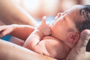 大人に抱かれた新生児