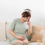 陣痛が始まって誰かに電話している妊婦