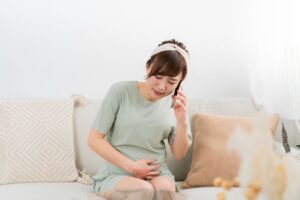 陣痛が始まって誰かに電話している妊婦