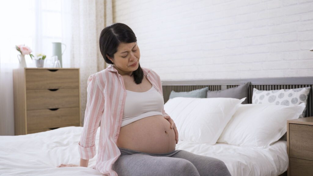 お腹を押さえている妊婦