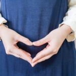 お腹の前で手でハートマークを作る妊婦
