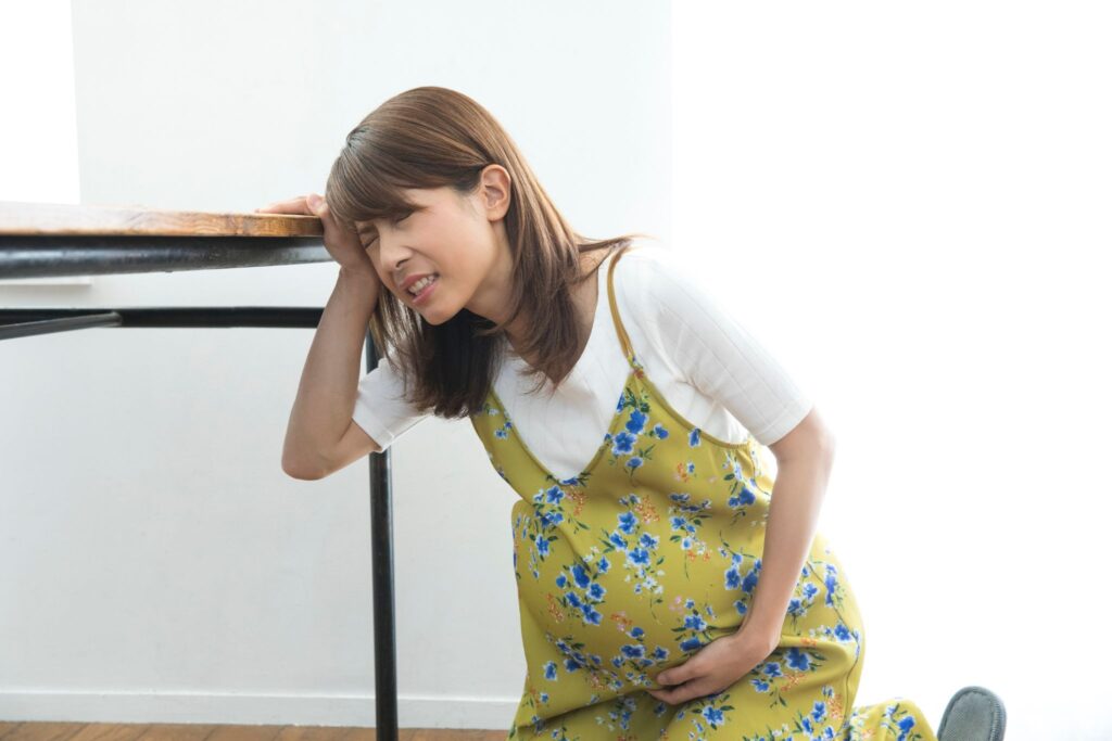陣痛でお腹を押さえている妊婦