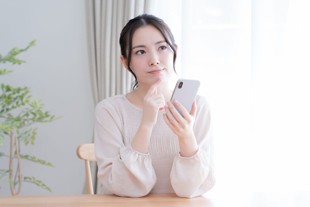 ピルの飲み忘れを防ぐ工夫についてスマホで調べている女性