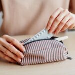 ポーチからピルを出している女性
