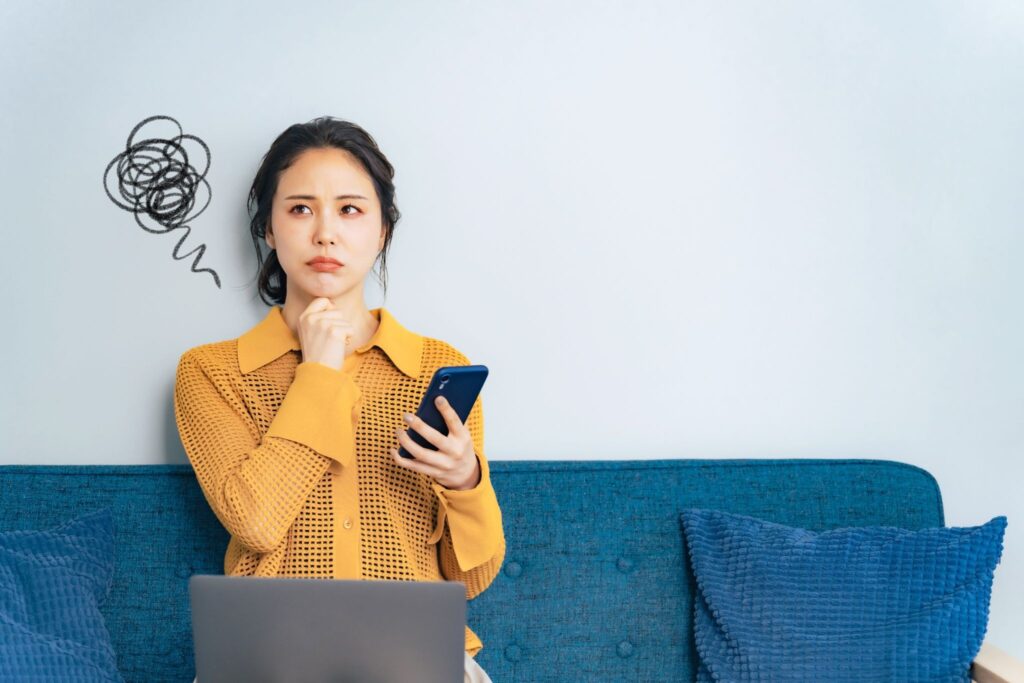 ピルを飲み忘れてしまった女性。スマホで対処法を調べている