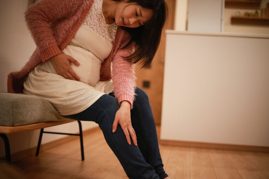 陣痛が来てお腹を押さえている妊婦