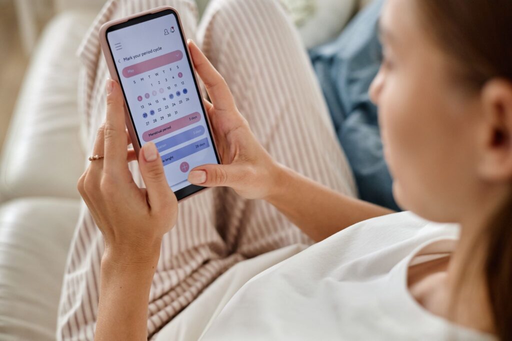 スマホで生理周期をチェックしている女性