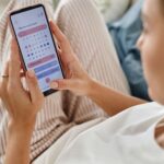 スマホで生理周期をチェックしている女性