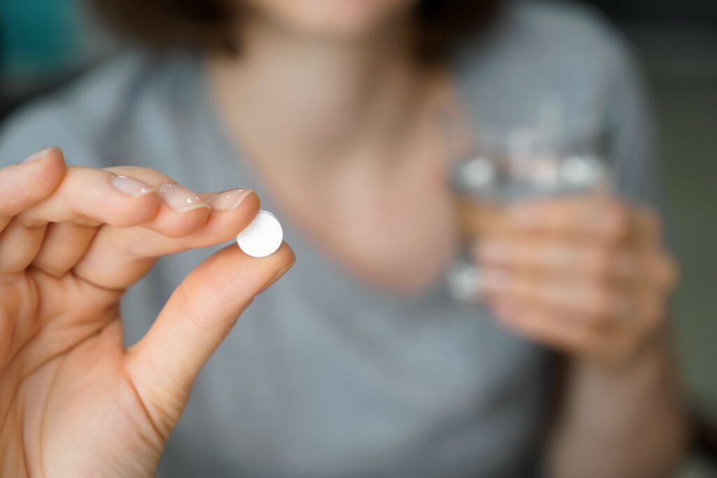 錠剤を持つ女性の手