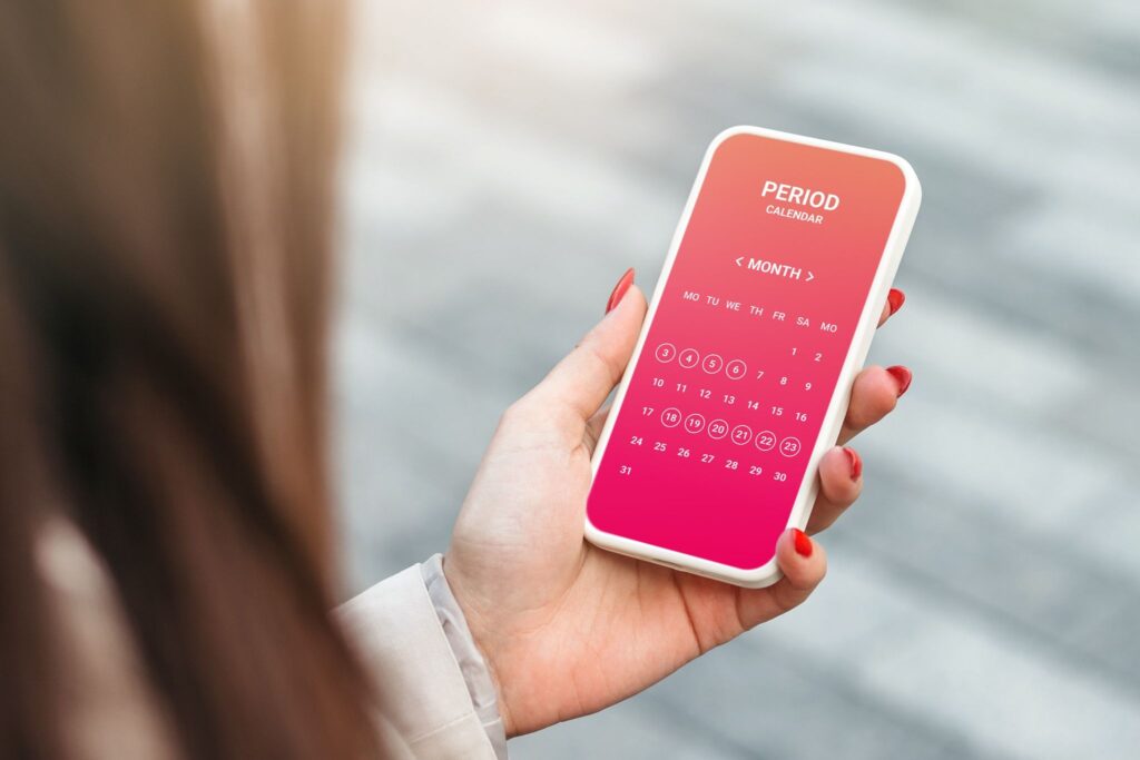 スマホで生理周期を見ている女性