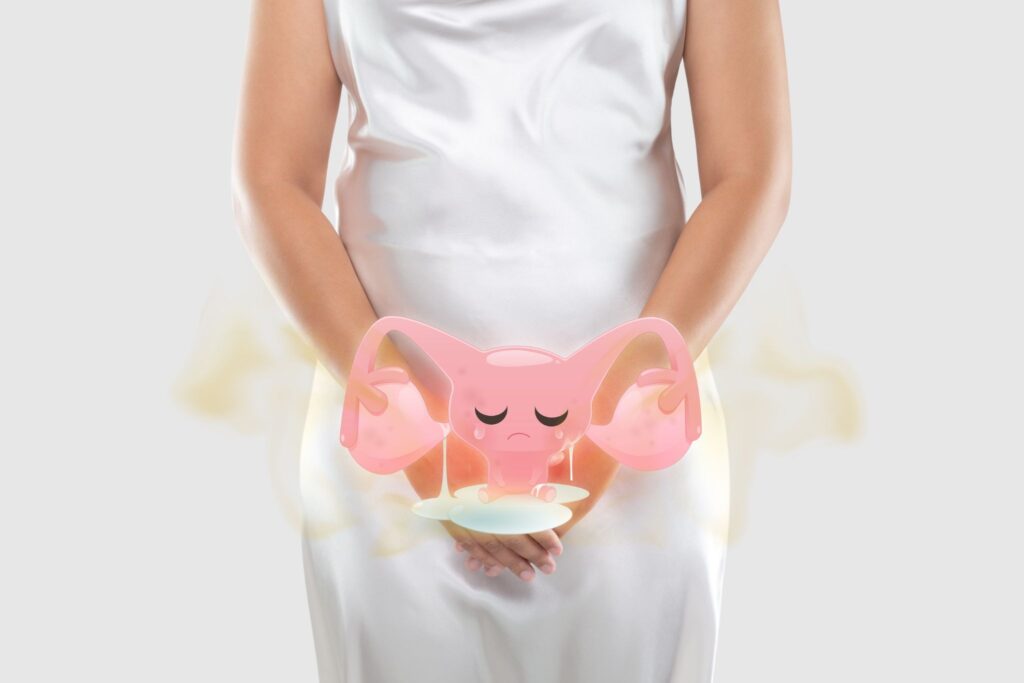 下腹部を押さえている女性と臭いがしている子宮のイラスト