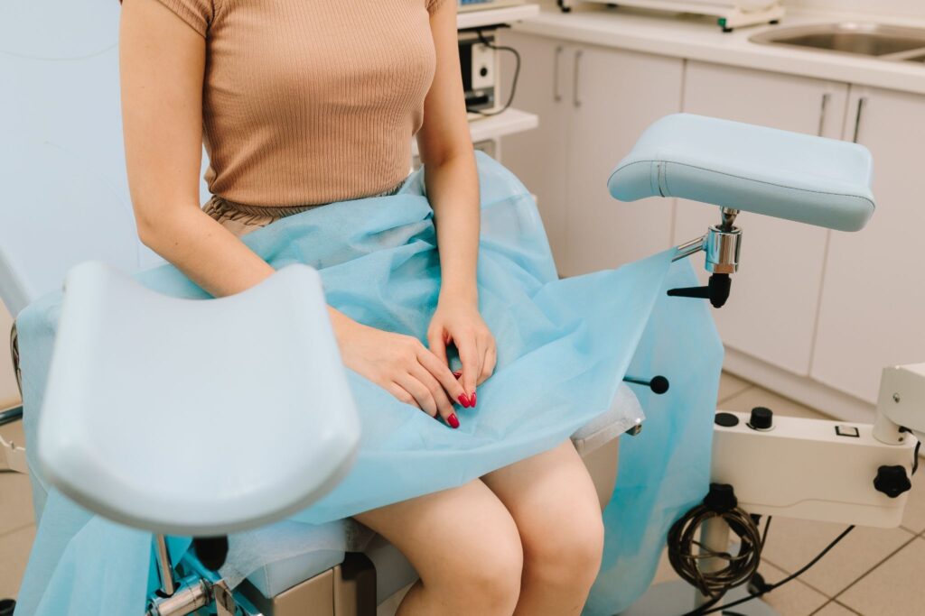 婦人科で検査用の椅子に座っている女性