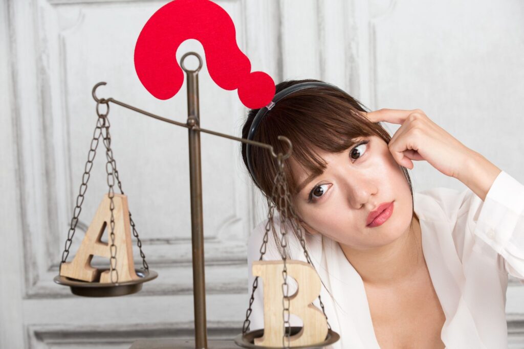AとBが乗った天秤とはてなマークのカチューシャを付けて首を傾げる女性