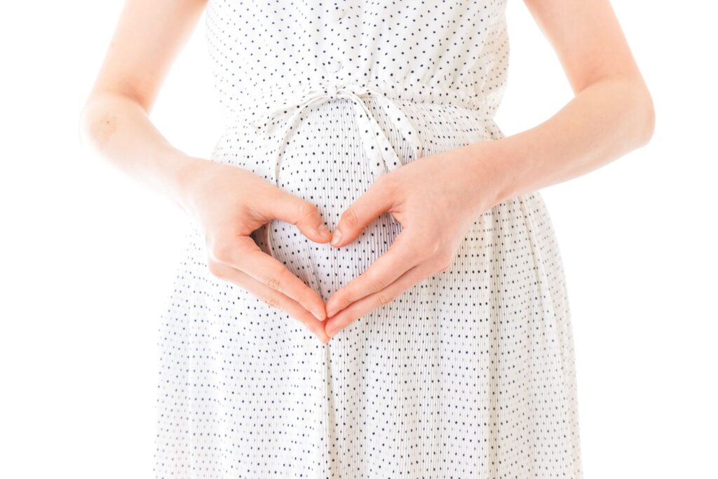 お腹の前で両手でハートマークを作る妊婦