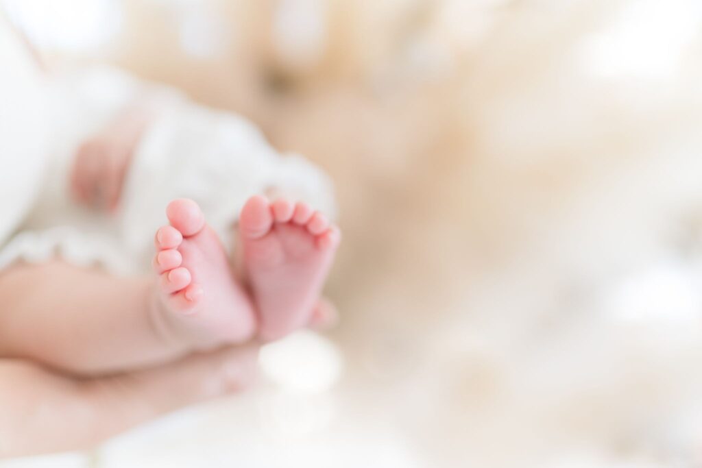 大人に抱かれた新生児の足