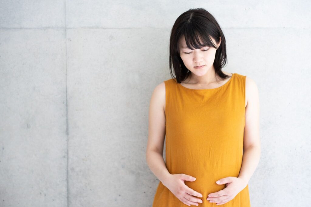 お腹を押さえている妊婦
