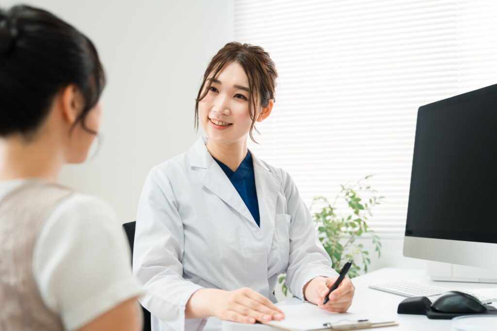 つわりで医師に相談している女性