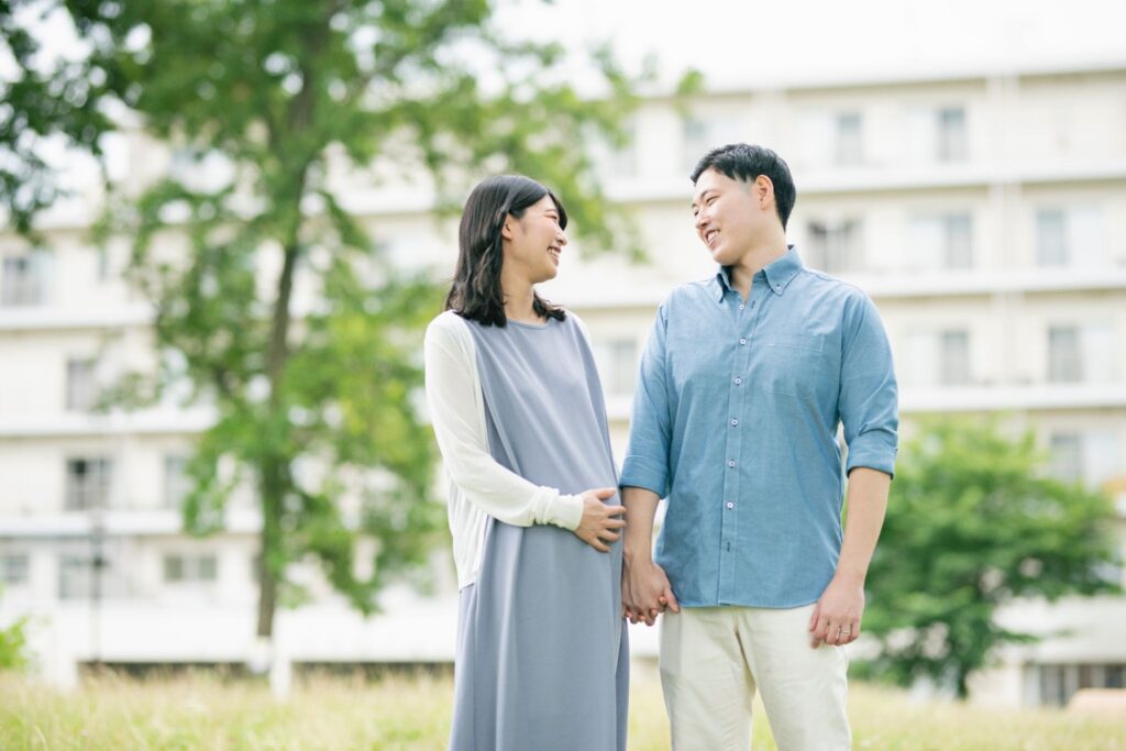 手を繋いでいる妊婦と夫